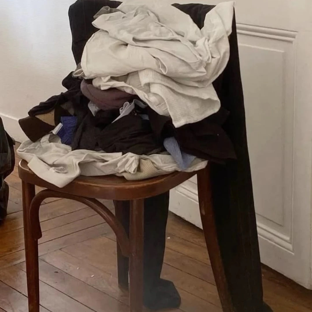 Clothes piled high on a bentwood chair